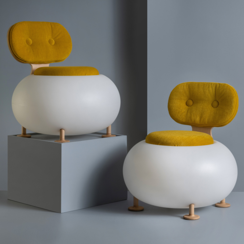 two Candy chairs with yellow cushions on a grey background