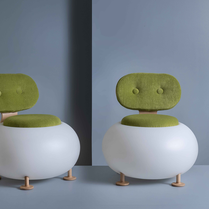 two Candy chairs with green cushions on a grey background